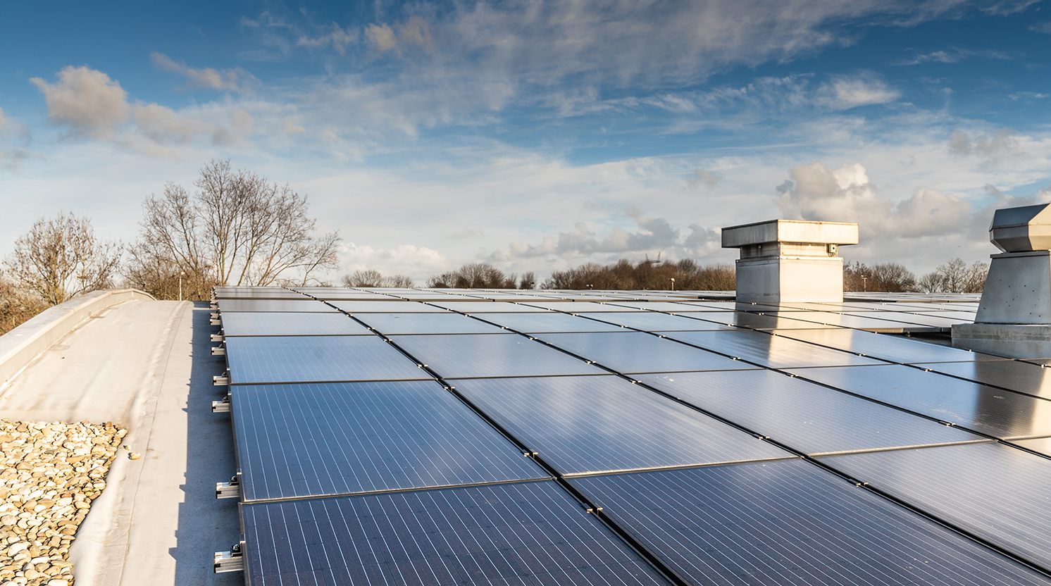 Zonnepanelen op het gebogen stalen dak van sporthal De Bloemerd